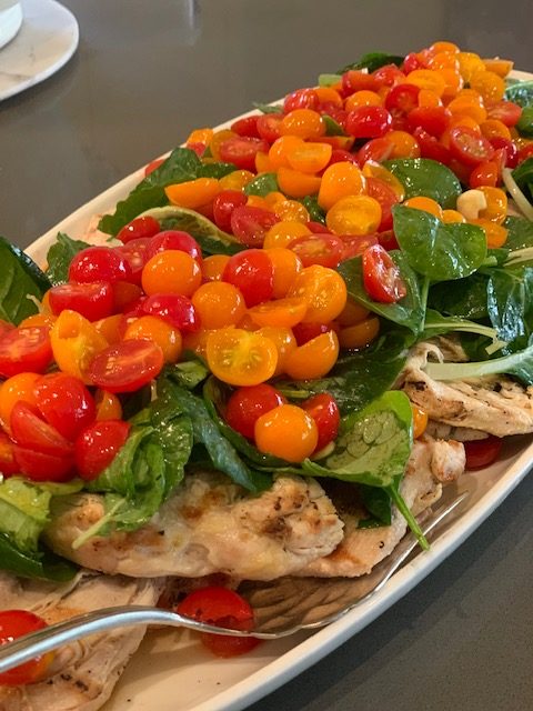 Grilled chicken with fresh spinach and cherry tomatoes