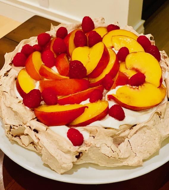 A Pavlova topped with Cream and Fresh Fruit